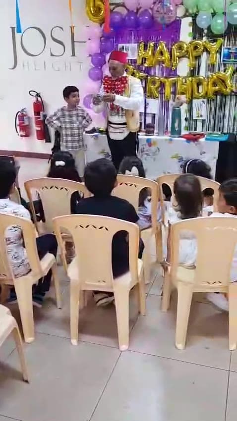 Sadiq on stage before a room of seated children
