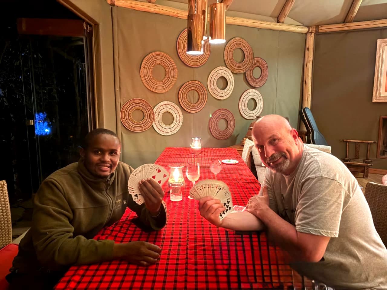 Screbick performing close-up card magic for a guest at a candlelit table